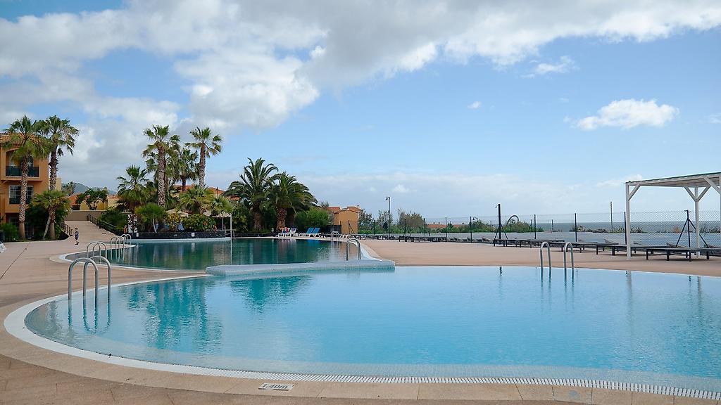Hotel Las Olas, Ein weiterer Blick auf den Hotel-Außenpool mit glitzerndem Wasser, Sonnenliegen und angrenzenden Grünflächen.