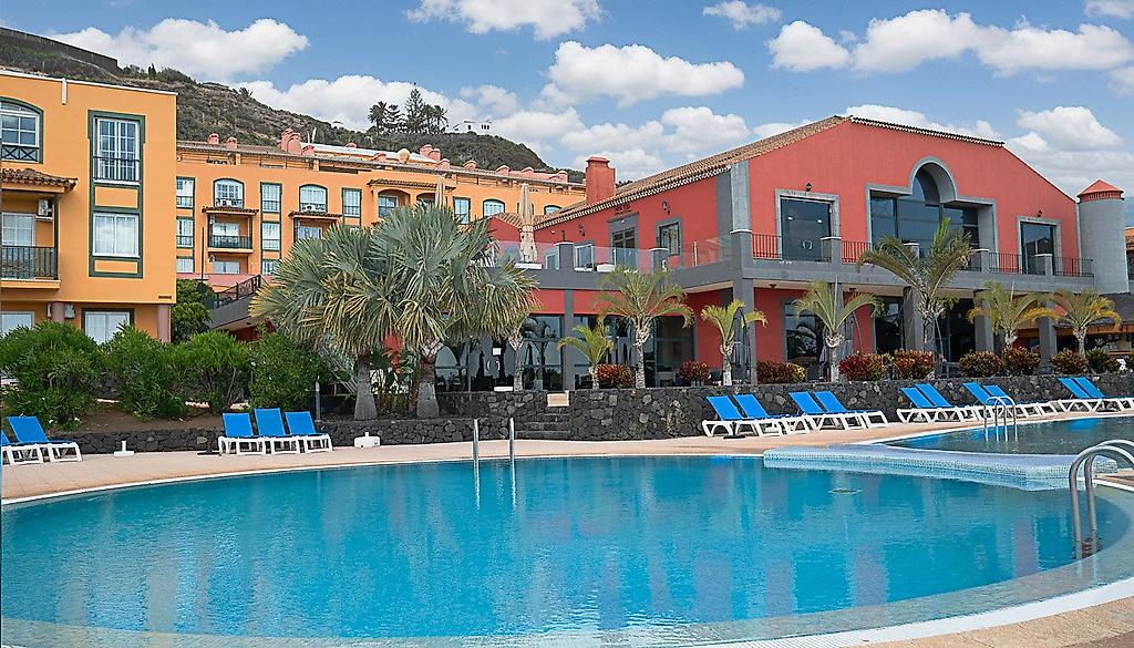 Hotel Las Olas, Großzügiger Außenpool des Hotels, umgeben von Liegestühlen, Sonnenschirmen und Palmen unter klarem Himmel.