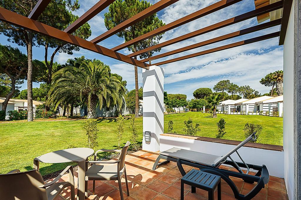 Pestana Vila Sol, Vilamoura – Premium Golf & Spa Resort, Komfortables Doppelbett im Superior-Gartenzimmer mit dekorativen Kissen und Nachttischen.