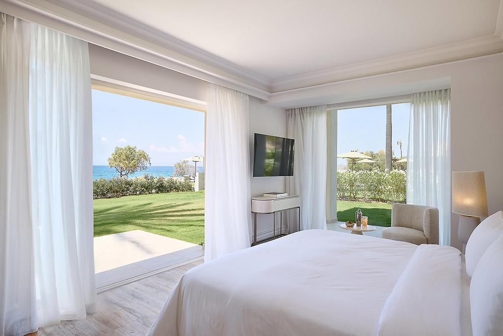 Grecotel Filoxenia Kalamata, Stilvolle Deluxe Suite mit direktem Blick auf das Meer und Palmen.