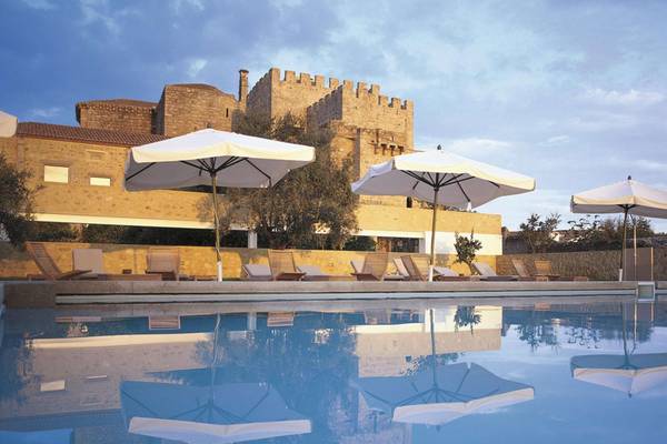 Pousada in Portugal mit Sonnenschirmen am Pool und Gebäude mit Burg im Hintergrund