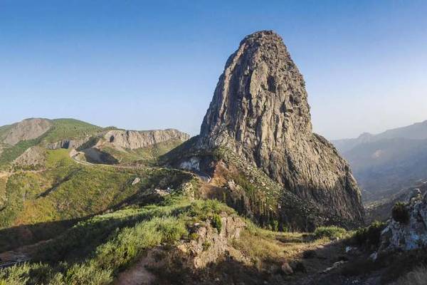 Bergkulisse mit grünen Wiesen und kargen Felsen