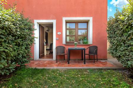 Alghero Resort Country Hotel, Privater Patio eines Zimmers mit Sitzgelegenheit, umgeben von typisch italienischem Flair.