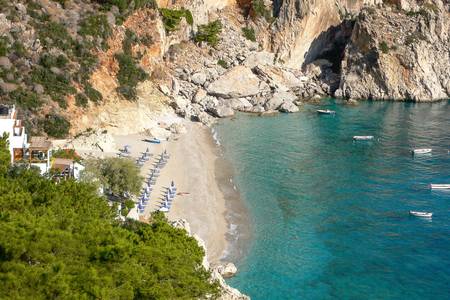 Akropolis Pension, Malerischer Strandabschnitt mit feinem Sand und sanft auslaufenden Wellen an einer mediterranen Küste.