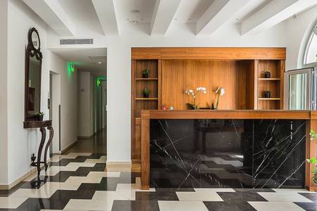 Aenos Hotel, Elegante Hotel-Lobby mit traditionellen Akzenten, gemütlichen Sitzmöbeln und hellem Boden.