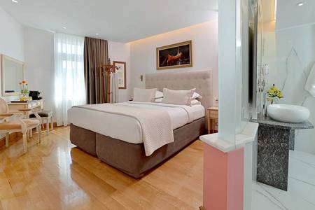 Acropolian Spirit Boutique Hotel, Gemütlicher Schlafbereich eines Zimmers mit dezenter Beleuchtung und harmonischer Farbgestaltung.