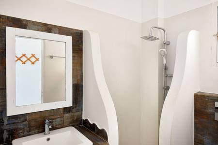 Glaros, Zimmer/Wohnbeispiel Glaros, Modernes Badezimmer mit ebenerdiger Dusche, weißem Waschbecken und Handtuchwärmer.