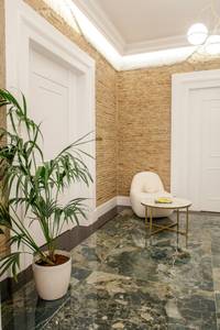La Divina – Aria Hotels, Eleganter Hotelkorridor mit hellem Teppichboden, moderner Beleuchtung und dunklen Zimmertüren.