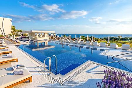 Amàre Beach Hotel Sancti Petri, Pool/Poolbereich Amàre Beach Hotel Sancti Petri, Nahaufnahme eines kristallblauen Hotelpools mit Blick auf moderne Hotelgebäude und grüne Gartenanlagen im Hintergrund.