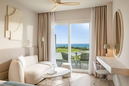 Amàre Beach Hotel Sancti Petri, Zimmer/Wohnbeispiel Amàre Beach Hotel Sancti Petri, Heller Hotelbalkon mit Tisch und Stühlen, der einen weiten Panoramablick über den Sandstrand auf das tiefblaue Meer bietet.