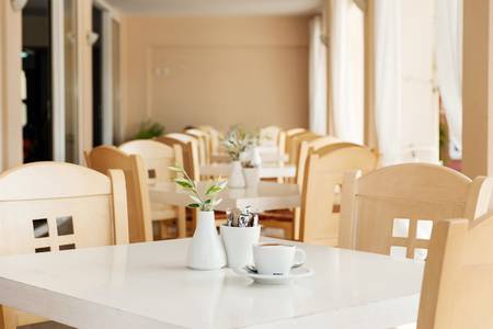 Ammos Bay, Restaurant mit gedeckten Tischen und gemütlicher Atmosphäre