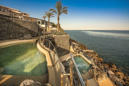 Therasia Resort Sea & Spa, Detailansicht des Poolwassers mit Sonnenreflexionen.