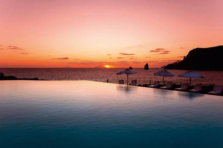 Therasia Resort Sea & Spa, Sonnenterrasse am Pool mit Blick auf die Küste.