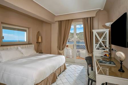 Therasia Resort Sea & Spa, Zimmer/Wohnbeispiel Therasia Resort Sea & Spa, Modernes Comfort-Zimmer mit Doppelbett und hellem Dekor sowie Blick auf das Meer.