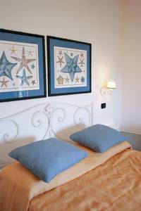 La Salina Borgo di Mare, Zimmer/Wohnbeispiel La Salina Borgo di Mare, Gemütliches Schlafzimmer mit hellem Holz, hochwertigen Textilien und direktem Zugang zum Außenbereich.