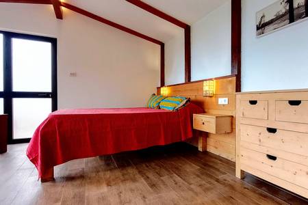 Casa Cavoquinho, Ansicht eines hellen Schlafzimmers mit Fenster zur umliegenden Natur.