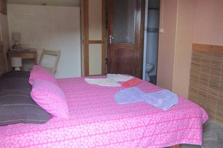 Casa das Ilhas, Zimmer/Wohnbeispiel Casa das Ilhas, Helles Hotelzimmer mit Doppelbett, Holzmöbeln und direktem Zugang zu einer Terrasse mit Blick auf die Berge.