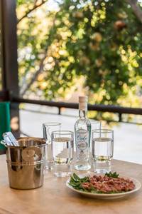 Villa Ganios, Außenbereich des Restaurants mit Blick auf den Garten und eleganter Bestuhlung.