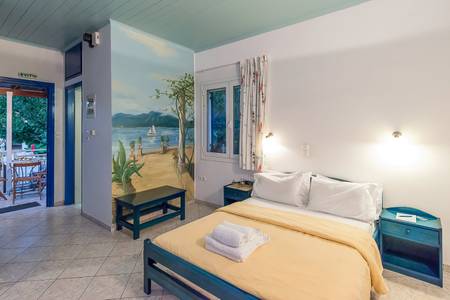 Villa Ganios, Modernes Hotelzimmer mit minimalistischem Design, Doppelbett und hellem Laminatboden.