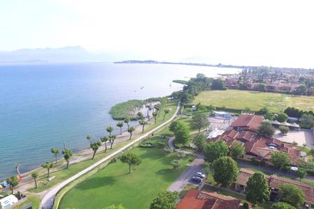 The Garda Village, Blick auf den angrenzenden Strandabschnitt am See mit Liegemöglichkeiten.