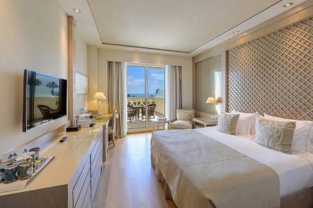 Hotel Las Arenas, Helles Deluxe-Zimmer mit Doppelbett, integrierter Sitzecke und moderner Kunst an der Wand.