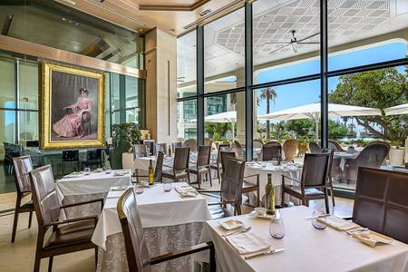 Hotel Las Arenas, Modernes Restaurant mit dunklen Akzenten, Holztischen und Designer-Stühlen.