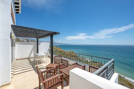 Olée Nerja Holiday Rentals, Balkon eines Apartments mit Sitzmöbeln und Meerblick.