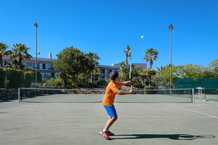 Pestana Vila Sol, Vilamoura – Premium Golf & Spa Resort, Außen-Tennisplatz aus Hartplatzmaterial mit Netz, umgeben von grüner mediterraner Vegetation.