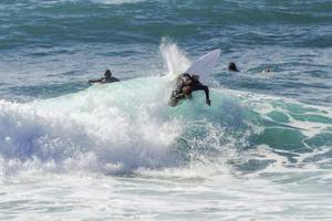 Surfer der eine Welle reitet Portugal