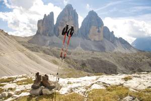 Wanderschuhe und Stücke vor der Kulisse der drei Zinnen in Südtirol