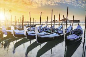 Gondeln auf dem Wasser bei Abendsonne in Venedig