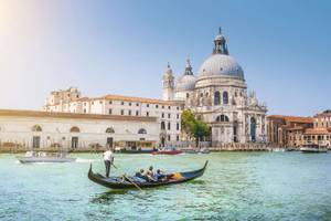 Gondel und Boote auf dem Canal Grande mit imposantem Gebäude im Hintergrund