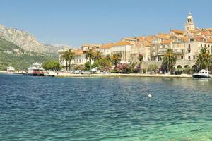 Küste auf Korcula mit Palmen und Häuser vom Wasser