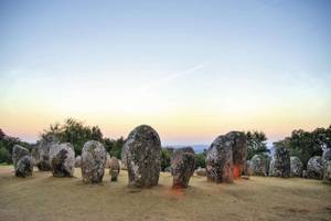 Steinkreis auf einer Wiese bei Sonnenuntergang bei Évora im Alentejo