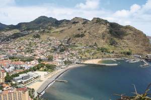 Küste von Maroços mit kleinem Strand und Bergen im Hintergrund