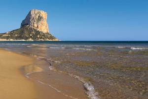 Strand Costa Blanca mit großem Felsen und blauer Himmel Spanien