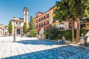 Platz in Granada mit Bäumen und Sträuchern und Kapelle