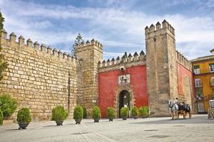 Königspalast Alcazar in Sevilla mit Kutsche und kleinen Sträuchern