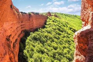 Las Médulas mit lehmfarbenen Formationen und grünen Bäumen in Kastilien León