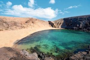 Papagayo Strand auf Lanzarote mit türkisblauem Wasser und schwarzen Lavafelsen und Sandstrand