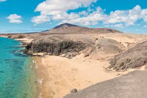 Felsige Küste mit Strand und klarem Wasser auf Lanzarote