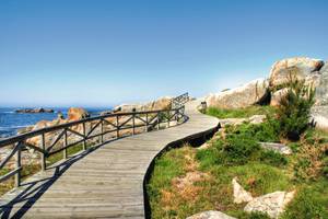 San Vicente Strand in Galicien - Holzsteg mit Geländer, blauem Himmel und Meer